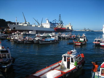 Cranes at harbor against clear sky