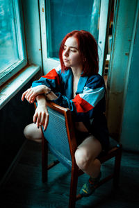 Young woman sitting on chair at home