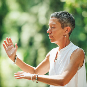 Woman practicing qi gong in a forest