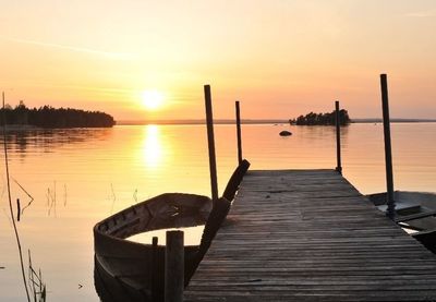 Pier in sea at sunset