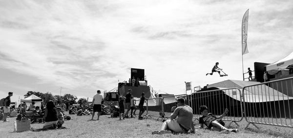 Panoramic view of people relaxing on grassland