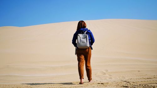 Rear view of man standing on desert
