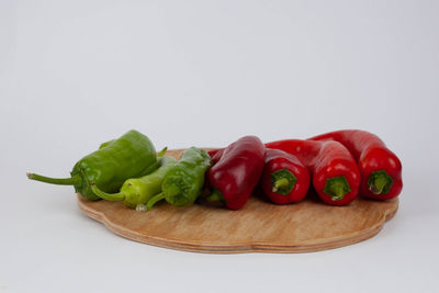 Close-up of fresh vegetables with chili pepper against white background