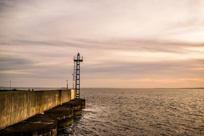 Pier against sky at sunset