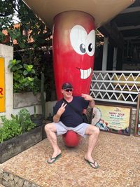 Full length portrait of young man sitting on mask
