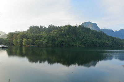 Scenic view of lake by trees against sky