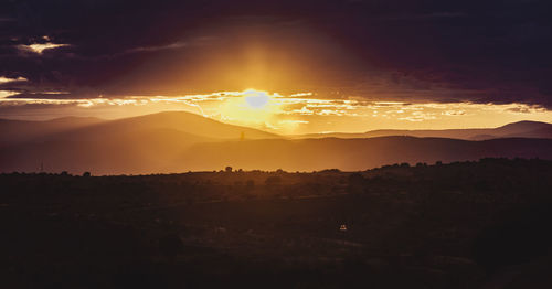 Scenic view of silhouette mountains against sky during sunset