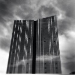 Low angle view of modern building against cloudy sky