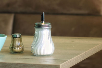 Close-up of sugar shaker and pepper shaker  on table