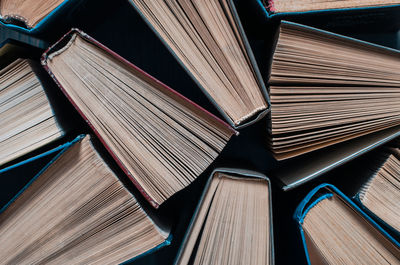 Parted books next to each other top view. background from multicolored old books.