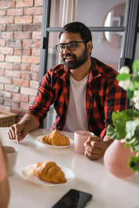 Portrait of young man sitting on table