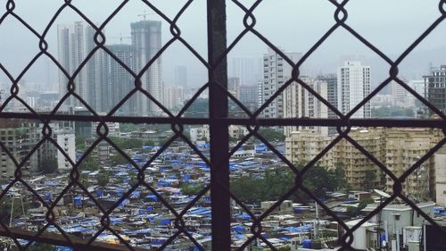 Cityscape seen through chainlink fence