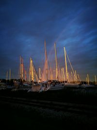 Sailboats moored in sea against sky