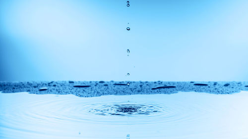 Close-up of water splashing against blue sky