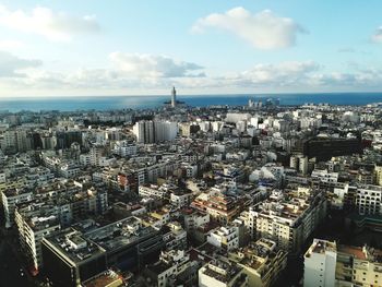 High angle view of city by sea against sky