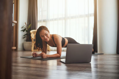 Smiling woman exercising on floor at home