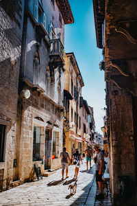 People walking on street amidst buildings in city