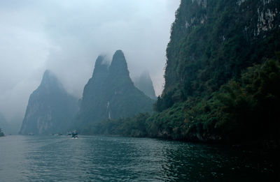 Scenic view of river and mountains against sky