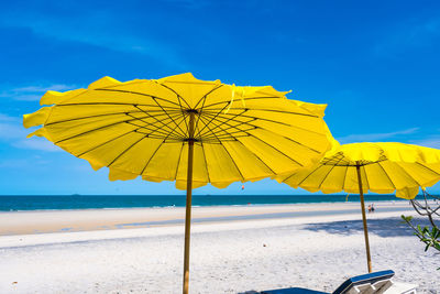 Yellow umbrella on beach against sky