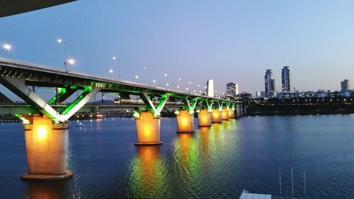 Illuminated bridge over river at night