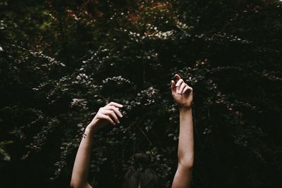 Cropped hands of woman against trees