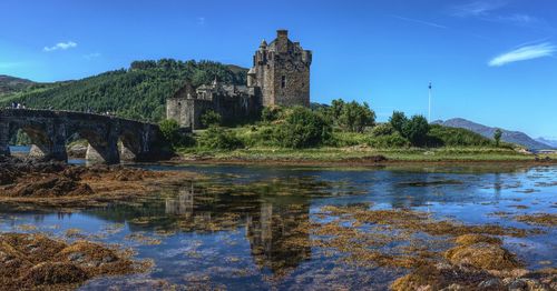 Reflection of on water against blue sky in eilean donan castle