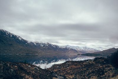 Scenic view of lake against cloudy sky