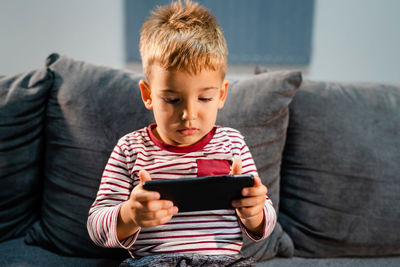 Boy sitting on sofa at home