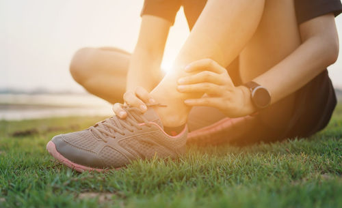 Low section of person relaxing on field