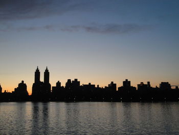 Silhouette of buildings in city at sunset