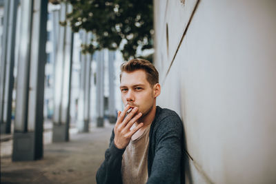 Young man smoking cigarette outdoors