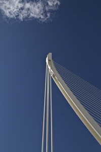 Low angle view of modern bridge against blue sky on sunny day