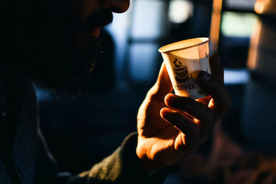 Cropped image of man holding disposable cup