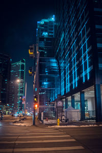 Illuminated city street and buildings at night