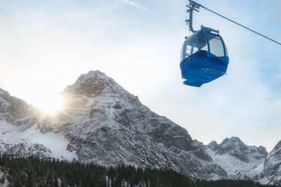 Low angle view of overhead cable car against sky