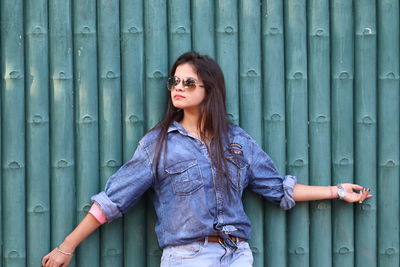 Portrait of young woman wearing sunglasses standing outdoors