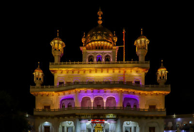 Low angle view of illuminated building against sky at night