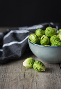 Bowl of brussels sprouts and napkin on a rustic wooden table.