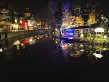 River amidst illuminated buildings in city at night