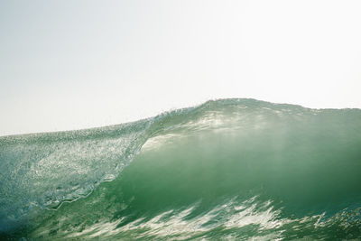 Ocean wave breaking in sintra portugal on a sunny day with pure green water