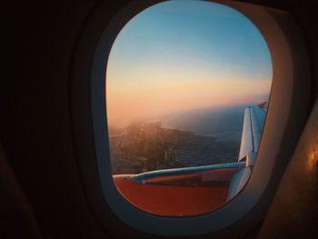 Landscape seen through airplane window during sunset