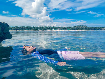 Man swimming in sea against sky