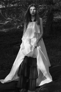 Portrait of a beautiful young woman standing on field