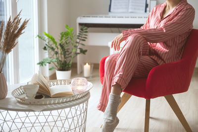 Woman sitting on table at home