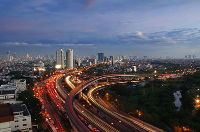 High angle view of illuminated city street and buildings against sky