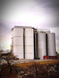 Factory on field against sky