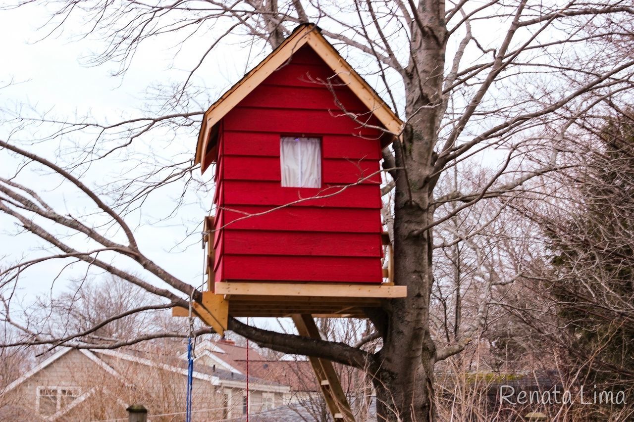 LOW ANGLE VIEW OF RED BIRDHOUSE