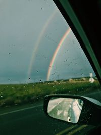 Road seen through wet glass window during rainy season