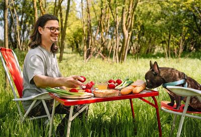 Smiling man and french bulldog dog eating easter lunch