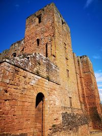 Low angle view of old building against blue sky